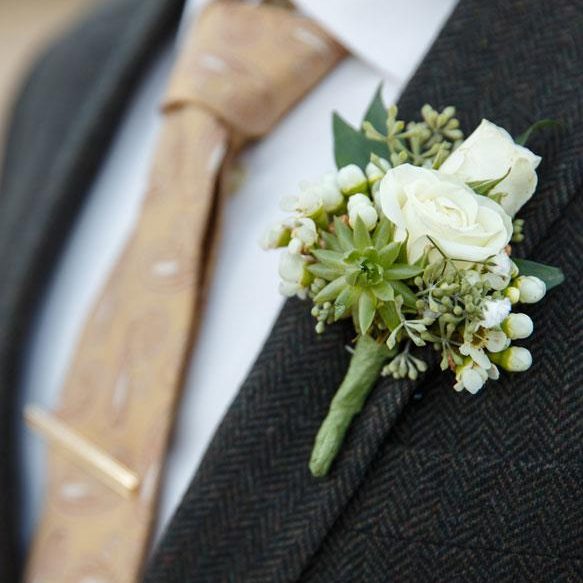 Close up of a grooms wedding boutonnière on his suit