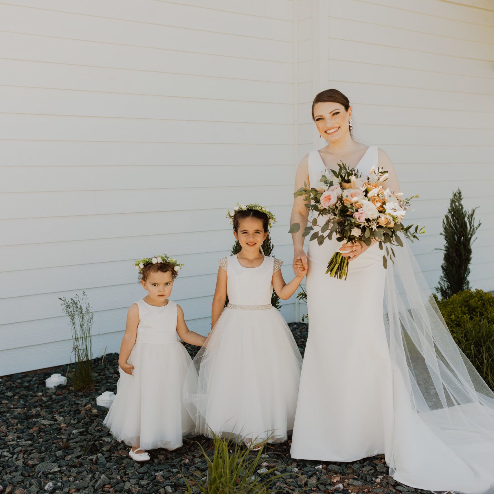 Katie with her daughters holding her wedding flower bouquet